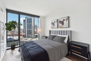A bedroom with a large bed and a view of the city.